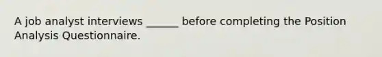 A job analyst interviews ______ before completing the Position Analysis Questionnaire.