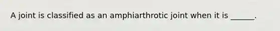 A joint is classified as an amphiarthrotic joint when it is ______.