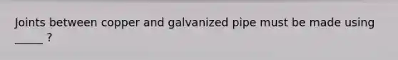 Joints between copper and galvanized pipe must be made using _____ ?