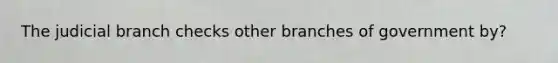 The judicial branch checks other branches of government by?