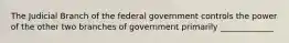 The Judicial Branch of the federal government controls the power of the other two branches of government primarily _____________