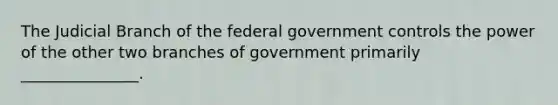 The Judicial Branch of the federal government controls the power of the other two branches of government primarily _______________.