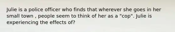 Julie is a police officer who finds that wherever she goes in her small town , people seem to think of her as a "cop". Julie is experiencing the effects of?