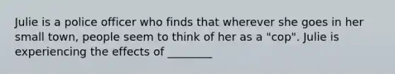 Julie is a police officer who finds that wherever she goes in her small town, people seem to think of her as a "cop". Julie is experiencing the effects of ________