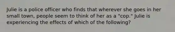 Julie is a police officer who finds that wherever she goes in her small town, people seem to think of her as a "cop." Julie is experiencing the effects of which of the following?