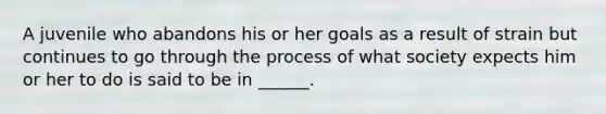 A juvenile who abandons his or her goals as a result of strain but continues to go through the process of what society expects him or her to do is said to be in ______.