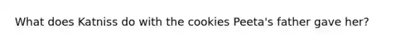 What does Katniss do with the cookies Peeta's father gave her?