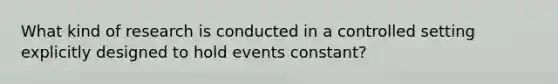 What kind of research is conducted in a controlled setting explicitly designed to hold events constant?