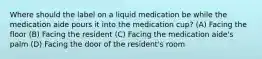 Where should the label on a liquid medication be while the medication aide pours it into the medication cup? (A) Facing the floor (B) Facing the resident (C) Facing the medication aide's palm (D) Facing the door of the resident's room