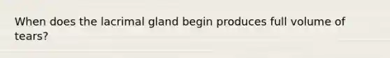 When does the lacrimal gland begin produces full volume of tears?