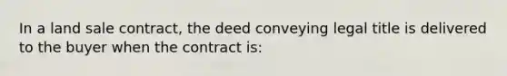 In a land sale contract, the deed conveying legal title is delivered to the buyer when the contract is: