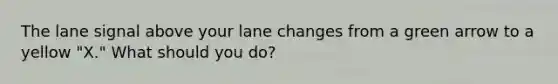 The lane signal above your lane changes from a green arrow to a yellow "X." What should you do?