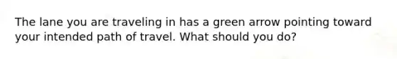 The lane you are traveling in has a green arrow pointing toward your intended path of travel. What should you do?