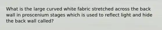 What is the large curved white fabric stretched across the back wall in proscenium stages which is used to reflect light and hide the back wall called?