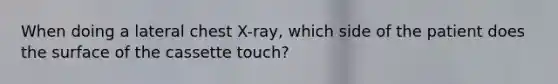 When doing a lateral chest X-ray, which side of the patient does the surface of the cassette touch?