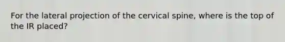 For the lateral projection of the cervical spine, where is the top of the IR placed?