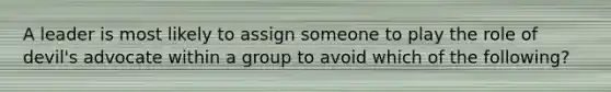 A leader is most likely to assign someone to play the role of devil's advocate within a group to avoid which of the following?