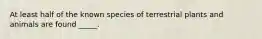 At least half of the known species of terrestrial plants and animals are found _____.