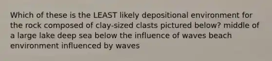 Which of these is the LEAST likely depositional environment for the rock composed of clay-sized clasts pictured below? middle of a large lake deep sea below the influence of waves beach environment influenced by waves