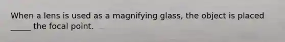 When a lens is used as a magnifying glass, the object is placed _____ the focal point.