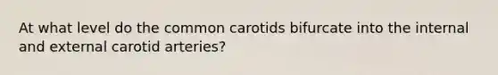 At what level do the common carotids bifurcate into the internal and external carotid arteries?