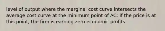 level of output where the marginal cost curve intersects the average cost curve at the minimum point of AC; if the price is at this point, the firm is earning zero economic profits