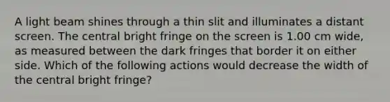 A light beam shines through a thin slit and illuminates a distant screen. The central bright fringe on the screen is 1.00 cm wide, as measured between the dark fringes that border it on either side. Which of the following actions would decrease the width of the central bright fringe?