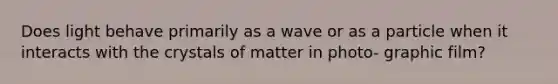 Does light behave primarily as a wave or as a particle when it interacts with the crystals of matter in photo- graphic film?