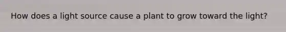 How does a light source cause a plant to grow toward the light?