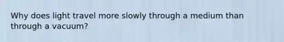 Why does light travel more slowly through a medium than through a vacuum?