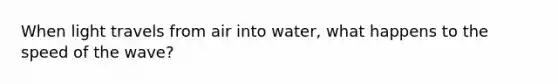 When light travels from air into water, what happens to the speed of the wave?