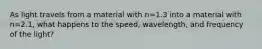 As light travels from a material with n=1.3 into a material with n=2.1, what happens to the speed, wavelength, and frequency of the light?