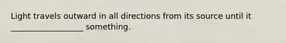 Light travels outward in all directions from its source until it __________________ something.