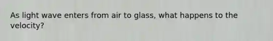 As light wave enters from air to glass, what happens to the velocity?