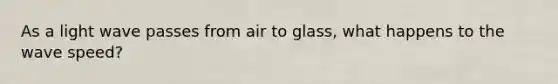 As a light wave passes from air to glass, what happens to the wave speed?