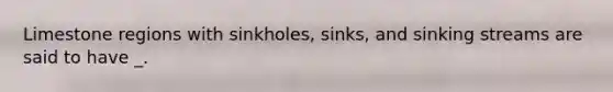 Limestone regions with sinkholes, sinks, and sinking streams are said to have _.