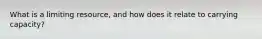 What is a limiting resource, and how does it relate to carrying capacity?