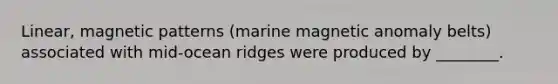 Linear, magnetic patterns (marine magnetic anomaly belts) associated with mid-ocean ridges were produced by ________.