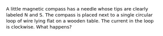 A little magnetic compass has a needle whose tips are clearly labeled N and S. The compass is placed next to a single circular loop of wire lying flat on a wooden table. The current in the loop is clockwise. What happens?