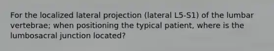 For the localized lateral projection (lateral L5-S1) of the lumbar vertebrae; when positioning the typical patient, where is the lumbosacral junction located?