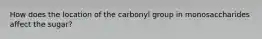 How does the location of the carbonyl group in monosaccharides affect the sugar?