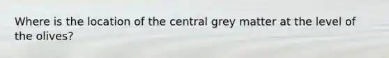 Where is the location of the central grey matter at the level of the olives?