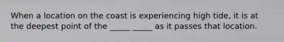 When a location on the coast is experiencing high tide, it is at the deepest point of the _____ _____ as it passes that location.