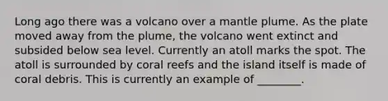 Long ago there was a volcano over a mantle plume. As the plate moved away from the plume, the volcano went extinct and subsided below sea level. Currently an atoll marks the spot. The atoll is surrounded by coral reefs and the island itself is made of coral debris. This is currently an example of ________.