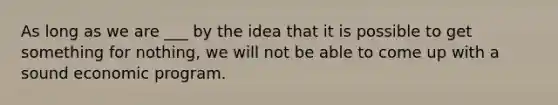 As long as we are ___ by the idea that it is possible to get something for nothing, we will not be able to come up with a sound economic program.