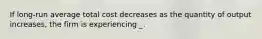 If long-run average total cost decreases as the quantity of output increases, the firm is experiencing _.