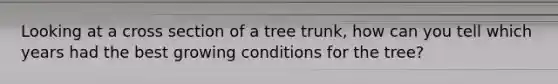 Looking at a cross section of a tree trunk, how can you tell which years had the best growing conditions for the tree?