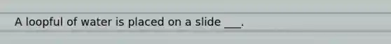 A loopful of water is placed on a slide ___.