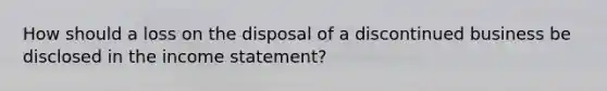 How should a loss on the disposal of a discontinued business be disclosed in the income statement?