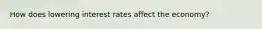 How does lowering interest rates affect the economy?